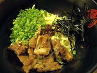 Abura Soba original disajikan bersama irisan daun bawang, fillet ayam panggang, irisan rumput laut, dan sedikit taberu rayu. Soba ini terasa gurih dengan sengatan pedas yang samar-samar.