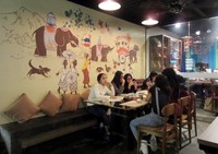 Dengan konsep homey, dindingnya terdapat mural dengan gambar gajah dan beberapa orang Sri Lanka. Dengan tempat duduk warna-warni berkonsep vintage.