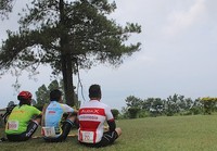 Melepaskan penat sehabis menggowes, sambil menikmati keindahan alam Danau Toba di hamparan rerumputan nan hijau di Bukit Simarjarunjung.