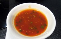 Racikan saus Coca Suki dibuat dari bumbu rahasia. Nampak butiran cabai dan cincangan daun ketumbar di permukaan saus bercita rasa asam manis pedas ini.