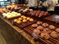 Di lantai satu kafe ada jejeran roti dan pastry di atas papan kayu cokelat serta cake di etalase kaca sudah menanti. Misalnya croissant, roti gaya adonan Danish, scone, dan bagel.