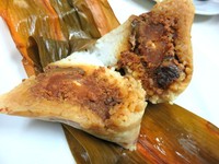 Bacang Beras Spesial Komplet dengan Kuning Telur Asin begitu memuaskan. Isiannya daging ayam, potongan jamur hioko, dan kuning telur asin. Tercecap paduan gurih manis yang lebih kaya karena ada rasa asin dari kuning telur yang masir.