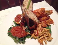 Nasi Campur Bali dengan Udang memadukan nasi aromatik gaya Bali dengan berbagai pelengkap. Nasi bakar disajikan bersama ayam sisit, kering kentang, plecing kangkung, sate lilit, udang bakar, dan setengah potong telur rebus sambal. Komplet!