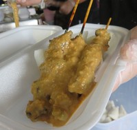 Sate ayam disiram dengan bumbu kacang gurih yang enak dipadukan dengan ketupat.