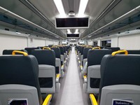 Deretan kursi di gerbong kereta bandara dengan kompartemen di atasnya Deretan kursi di gerbong kereta bandara dengan kompartemen di atasnya