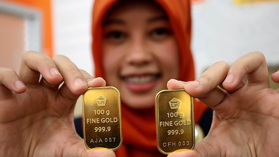 Seorang customer service Bank BNI Syariah cabang Benhil Jakarta Pusat menunjukkan logam mulia emas batangan berukuran 10 dan 100 gram, akhir pekan lalu. Berdasarkan data Asosiasi Pengusaha Emas dan Permata Indonesia, penjualan emas terus meningkat meskipun nilai tukar rupiah anjlok terhadap dollar AS. Jakarta (8/26/2013)