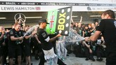 Presiden Rusia Vladimir Putin memberi ucapan selamat pada pebalap Mercedes Formula 1 Lewis Hamilton dan Nico Rosberg saat berdiri di podium setelah memenangi balapan di Sirkuit Sochi Autodrom, Rusia, Minggu (12/10). (Reuters/ Maxim Shemetov).