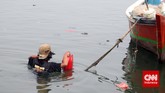 Nelayan membawa jerigen solar menuju kapalnya, di Pantai Tanjung Pasir, Kabupaten Tangerang, Banten, Selasa (11/11). (CNN Indonesia/Adhi Wicaksono)