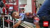 Demi memperoleh bahan bakar minyak sebelum harga baru diberlakukan, seorang bocah ikut mengantre membeli BBM bersubsidi di sebuah stasiun pengisian bahan bakar umum (SPBU) di Jakarta, Senin, 17 November 2014. (CNN Indonesia/Safir Makki)