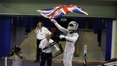 Seusai balapan, Lewis Hamilton langsung mengeluarkan bendera Inggris yang sudah ia persiapkan sebelumnya. Saat ini Hamilton sendiri tercatat sebagai pembalap paling sukses di Inggris sepanjang massa. (Reuters/Hamad I Mohammed)