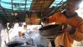 Seorang pekerja menuangkan solar hasil sulingan produksi sumur minyak mentah tradisional di Desa Wonocolo, Kedewan, Bojonegoro, Jawa Timu.