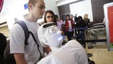 Alexander Herzog, mahasiswa doktoral di Max Planck Society, mendorong robot manusia Athena memasuki Bandara Internasional Los Angeles, Senin (15/12) waktu setempat. Robot yang bakal diterbangkan ke Jerman itu mengenakan pakaian sporty dan sepatu sneakers.