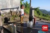 Seorang anak perempuan sedang mengisi jeriken air. Besarnya pasokan air dari mata air tergantung pada musim. Di musim hujan pasokan air akan lancar dengan debit air besar. Sebaliknya, di musim kemarau debit air sangat kecil. (CNN Indonesia/ Windratie)
