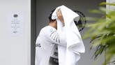 Usai menerobos hujan demi kualifikasi GP Malaysia, Hamilton pun mengeringkan rambutnya dengan handuk dan siap-siap beristirahat agar besok lebih fit pada hari balapan. (Reuters / Olivia Harris)