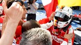 Sebastian Vettel berlari memeluk rekan-rekannya di tim Ferrari. Itu adalah kemenangan pertamanya bersama Ferrari dan juga kemenangan pertama tim asal Italia itu sejak Mei 2013. (Photo by Lars Baron/Getty Images)