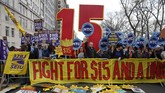 Demonstran juga berunjuk rasa juga terjadi di Manhattan, dengan membawa atribut angka 15 yang berarti kenaikan upah hingga US$15 per jam, bertepatan dengan pembatasan lapor pajak di AS yang jatuh pada tanggal 15 April 2015. (Reuters/Shannon Stapleton)