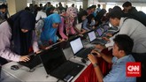 Para pencari kerja mengisi data di laptop yang disediakan penyelenggara saat pameran bursa kerja di Balai Kartini, Jakarta, Jumat (24/4). (CNN Indonesia/Safir Makki)