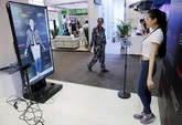 Seorang staf promosi mendemonstrasikan FXMirror, sebuah solusi kamar pas virtual yang dikembangkan oleh FXGear di Global Mobile Internet Conference (GMIC) 2015 di Beijing, Tiongkok. (CNN Indonesia/Reuters/Kim Kyung-Hoon)