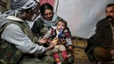Selain berperang, mereka menyempatkan untuk bersosialisasi, di antaranya dengan para wanita Yazidi di Sinjar yang tersingkir akibat gempuran ISIS. (Reuters/Asmaa Waguih)