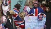 Para warga, loyalis keluarga Kerajaan Inggris, mengenakan kostum berornamen bendera Inggris atau Union Jack, seraya memamerkan poster berisikan ucapan selamat atas kelahiran putri pertama pasangan Pangeran William dan Kate Middleton, di St Mary's Hospital, London (2/5).