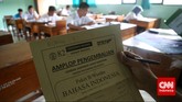 Pengawas ujian kesetaraan paket B di SMA Negeri 80, Jakarta Utara, menunjukkan amplop pengembalian lembar jawaban ujian Bahasa Indonesia. (CNN Indonesia/Safir Makki)