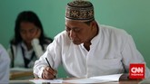Seorang bapak mengisi lembar ujian nasional kesetaraan paket B di SMA Negeri 80, Jakarta Utara, Senin, 4 Mei 2015. (CNN Indonesia/Safir Makki)