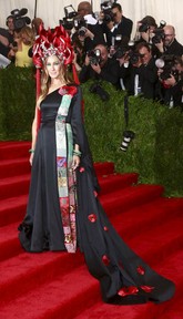 Sarah Jessica Parker tiba di Metropolitan Museum of Art Institute Gala dengan tampilan agar liar. Parker mengenakan topi baja rancangan desainer topi Philip Treacy, lengkap dengan jumbai api panjang dari beban merah berbulu. Parker mengenakan baju rancangannya sendiri yang berkolaborasi dengan H&M. (REUTERS/Andrew Kelly)