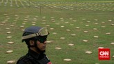 Petugas menjaga 2,1 ton ganja yang 'dipamerkan' Direktorat Tindak Pidana Narkoba Badan Reserse Kriminal di Lapangan Bhayangkara Mabes Polri, Jakarta, Senin (11/5). Ganja-ganja ini dibawa jaringan pengedar dari Aceh ke Jakarta. (CNN Indonesia/Adhi Wicaksono)