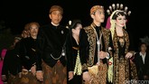 Di belakangnya, Joko Widodo didampingi oleh Iriana berjalan mengenakan pakaian berwarna senada dengan bawahan kain truntum. Begitu pula dengan kedua orang tua Selvi yang ada di belakang sang Presiden. (Detikcom/Agung Pambudhy)