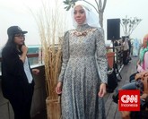 Busana lain menyuguhkan motif songket yang lebih ramai dengan warna biru. Bagian atas baju juga menutup leher hingga batas dagu. Sayangnya, tumpukan batu swarovski di bagian dada yang berpadu dengan motif songket membuat busana terlihat terlalu ramai.