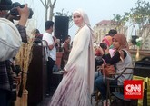 Rok tersebut dipadukan dengan blouse putih lengan panjang. Di bagian dada terdapat tumpukan batu swarovski yang membuat baju sederhana tersebut terlihat lebih mewah. (CNN Indonesia/Nadi Tirta Pradesha)