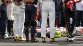 Sebelum dimulai, para pebalap meletakkan helm-helm mereka di aspal Sirkuit Hungaroring dan mengheningkan cipta atas wafatnya Jules Bianchi setelah sembilan bulan koma. (REUTERS/Laszlo Balogh)
