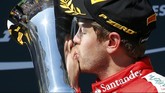 Kemenangan emosional bagi Vettel. Ia mencium trofi itu dan mempersembahkan kemenangannya untuk mendiang Jules Bianchi. (REUTERS/Laszlo Balogh)
