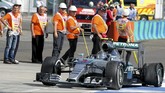 Pebalap Mercedes Nico Rosberg pelan-pelan kembali ke pit stop setelah ban mobilnya pecah usai bertabrakan dengan mobil pebalap tim Red Bull Daniel Ricciardo.(REUTERS/Ronald Zak)