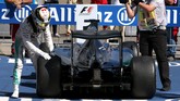 Kemenangan Hamilton sempat terancam karena tekanan ban kiri belakangnya tidak sesuai aturan. Pebalap Inggris itu lalu merayakan kemenangannya dengan memegang ban kiri tersebut. (Action Images/Livepic/Hoch Zwei)