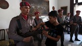 Petugas museum membersihkan patung deorama prajurit Tjakrabirawa di Museum Jendral Besar A.H Nasution, Jakarta, Rabu (30/9). (CNN Indonesia/ Safir Makki)