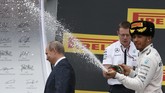 Setelah menyiram gadis panggung, Hamilton dianggap menyemprotkan sampanye ke Presiden Rusia, Vladimir Putin. Akan tetapi, aksi ini terbukti hanya trik foto belaka. (REUTERS/Grigory Dukor)