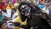 Seorang seniman menyamar seperti setan dalam sebuah drama keagamaan pada perayaan Festival Dussehra di Chandigarh, India. (Reuters Ajay Verma)