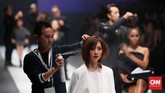 Beberapa penata rambut yang telah melalui proses audisi menunjukkan keahlian mereka menata rambut puluhan model di atas panggung Jakarta Fashion Week 2016. (CNN Indonesia/Safir Makki)