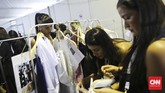 Penata busana menyiapkan pakaian salah satu model saat pergelaran Jakarta Fashion Week 2016 di Jakarta, Rabu (28/10). (CNN Indonesia/Adhi Wicaksono)
