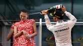 Lewis Hamilton sempat mendapat sorotan ketika ia menyemprot seorang gadis panggung seusai juara di GP China. Aksi Hamilton ini dianggap seksis dan ia menerima kecaman. (Getty Images/Dan Istitene)