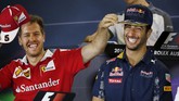 Daniel Ricciardo (kanan) tertawa ketika mendengar pertanyaan wartawan mengenai spekulasi dirinya akan bergabung dengan tim Ferrari dalam jumpa pers jelang musim balap 2016 di Melbourne, Australia, Kamis (17/3). Pebalap Ferrari Sebastian Vettel yang duduk di sebelahnya pun terbersit ide usil mendengarnya. (Reuters/Brandon Malone)