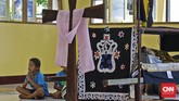Peziarah berdoa di samping Patung Jenazah Yesus dalam Keranda di Kapel Tuan Senhor, Wure, Adonara, NTT, Kamis (23/3). (CNN Indonesia/Adhi Wicaksono)