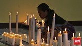 Peziarah menyalakan lilin di Kapel Tuan Senhor, Wure, Adonara, NTT, Kamis (23/3). Wure adalah salah satu lokasi pelaksanaan prosesi semana Santa selain kota Larantuka dan Konga. (CNN Indonesia/Adhi Wicaksono)