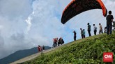Faktor cuaca dan angin bisa bahkan sangat menentukan layak terbang atau tidaknya sebuah penerbangan paralayang. Perlu di perhatikan bahwa bobot tubuh juga berpengaruh dalam terbang tandem paralayang, Jumat, 22 April 2016. (CNN Indonesia/Andry Novelino)