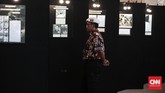 Seorang anggota ormas melihat-lihat foto di stan pameran pada acara Simposium Nasional 'Mengamankan Pancasila dari Kebangkitan PKI dan Ideologi Lain' yang berlangsung di Balai Kartini, Jakarta, Kamis (2/6). (CNN Indonesia/Andry Novelino)