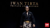 Gaya kain batik yang dipadukan dengan celana dan juga atasan beskap membuat tampilan pria jadi lebih formal. (CNN Indonesia/Djonet Sugiarto)