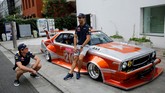 Dua pebalap tim Red Bull, Daniel Ricciardo (kanan) dan Max Verstappen (kiri) berpose bersama di depan mobil legendaris Jepang, Nissan Skyline buatan tahun 1979 yang telah dimodifikasi bentuk. (Reuters/Toru Hanai)