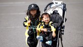 Dua bocah yang dibawa orang tuanya yang menggemari F1 berpose di arena paddock sirkuit Suzuka. (Reuters/Toru Hanai)