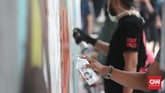 Jika teriakan dengan mikrofon tak didengar, dinding-dinding pun bisa bersuara. Itulah yang dilakukan seniman jalanan lewat mural atau grafiti. (CNN Indonesia/Andry Novelino)